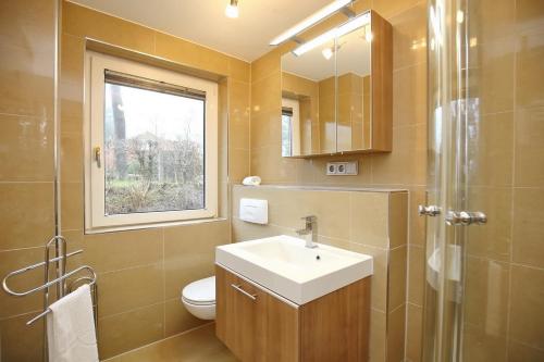 a bathroom with a sink and a toilet and a window at Urlauberdorf Haus 63a in Boltenhagen