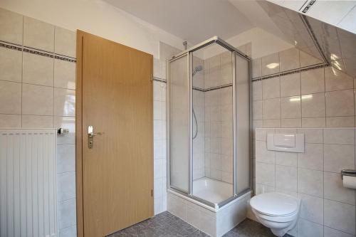 a bathroom with a toilet and a glass shower at Strandvilla Krabbe Wohnung 13 in Boltenhagen