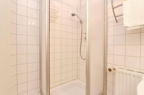 a white bathroom with a shower and a tub at Goosbrink Wohnung 14 in Boltenhagen