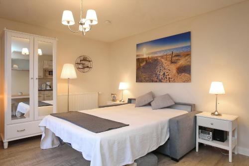 a bedroom with a large white bed in a room at Strandvilla Krabbe Wohnung 03 in Boltenhagen