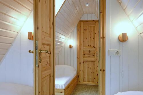 a small attic room with a bed and a door at An der Steilküste Finnhütte 01 in Boltenhagen