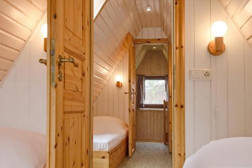 a small room with a bed and a door at An der Steilküste Finnhütte 01 in Boltenhagen