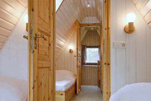 - une petite chambre mansardée avec un lit et une porte dans l'établissement An der Steilküste Finnhütte 02, à Boltenhagen