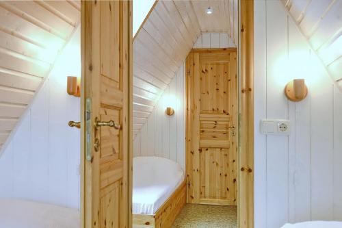 - une petite salle de bains mansardée avec baignoire dans l'établissement An der Steilküste Finnhütte 02, à Boltenhagen