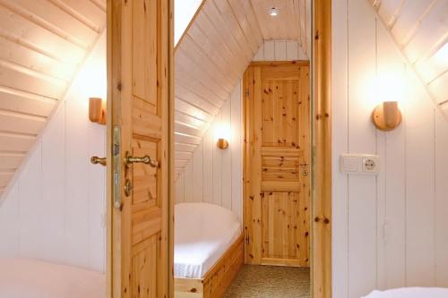 a small attic room with a bed and a tub at An der Steilküste Finnhütte 03 in Boltenhagen