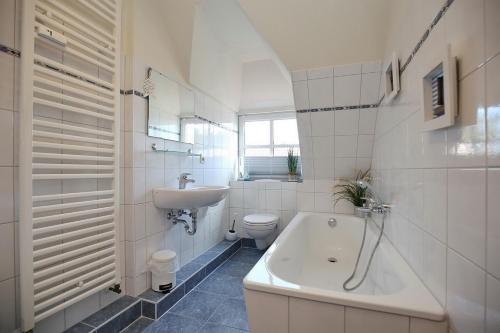 a bathroom with a tub and a sink and a toilet at Villa Triton Wohnung 06 in Boltenhagen