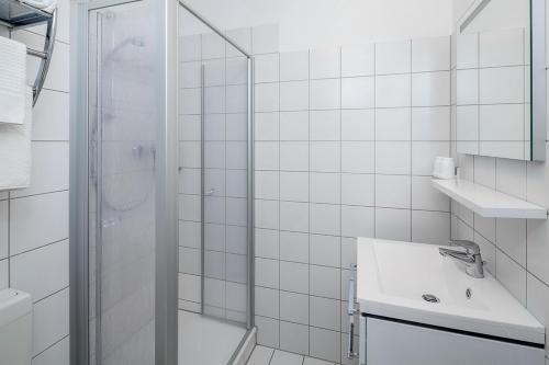 a white bathroom with a shower and a sink at Sünnslag Wohnung 012 in Boltenhagen