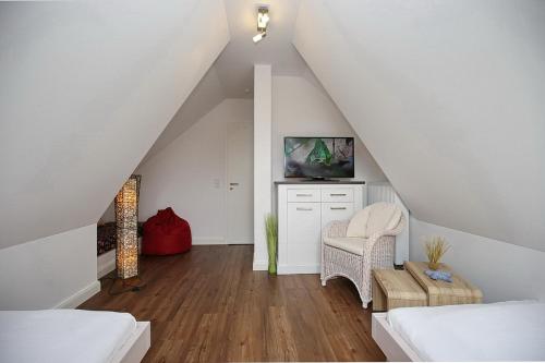 a attic bedroom with white walls and wood floors at Reethaus Am Mariannenweg 18a in Boltenhagen