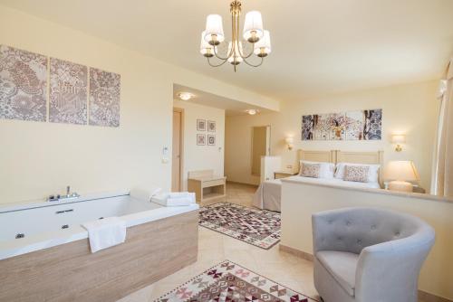 une grande salle de bains avec baignoire et une chambre dans l'établissement Hotel Regina Elena, à Olbia