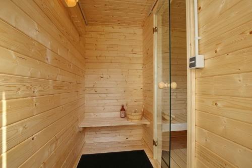 a sauna with wooden walls and a glass shower at Reethaus Am Mariannenweg 19a in Boltenhagen