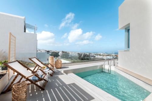 a balcony with a swimming pool and two chairs at Santo Bloom Luxury Villas in Vóthon