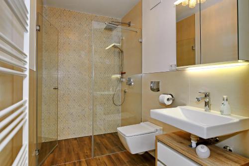 a bathroom with a sink and a shower and a toilet at Linden-Palais Wohnung 25 in Heiligendamm