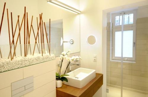a white bathroom with a sink and a mirror at Villa Rheingold - Lohengrin Wohnung 2 in Kühlungsborn