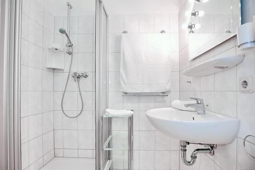 a white bathroom with a sink and a shower at Goosbrink Wohnung 15 in Boltenhagen