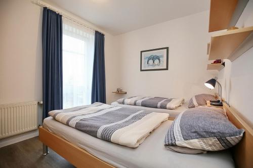 two beds in a room with a window at Dünenblick Wohnung 10 in Boltenhagen