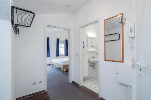 a room with a bathroom with a bed and a mirror at Godewind Wohnung 21 in Boltenhagen