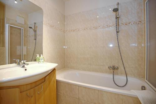y baño con bañera, lavamanos y ducha. en Villa Seepferdchen Wohnung 01, en Kühlungsborn