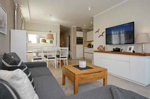 a living room with a couch and a table at Haus am Wald Wohnung Meer in Wittenbeck