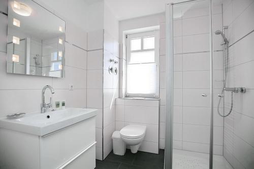 a white bathroom with a toilet and a sink at Likedeeler Wohnung 12 in Boltenhagen