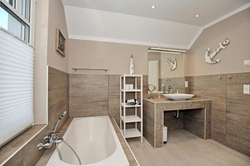 un ampio bagno con vasca e lavandino di Haus am Wald Wohnung Sonne a Wittenbeck