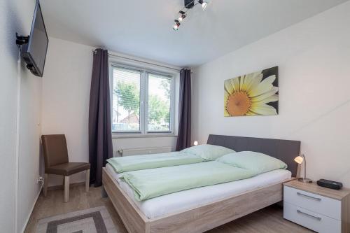 a bedroom with a bed with a sunflower picture on the wall at Sünnslag Wohnung 039 in Boltenhagen