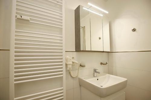 a white bathroom with a sink and a mirror at Sünnslag Wohnung 039 in Boltenhagen