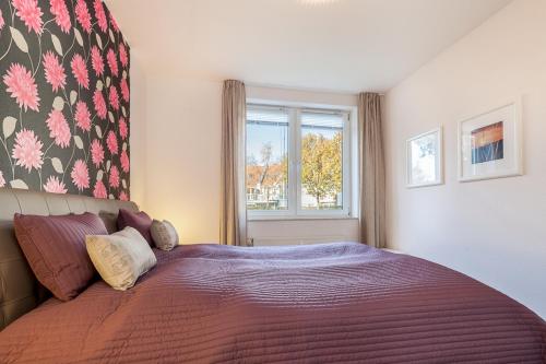 a bedroom with a large bed with a window at Sünnslag Wohnung 097 in Boltenhagen