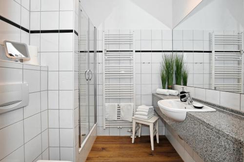 a white bathroom with a sink and a shower at Meeresblick Wohnung 005 - 4 Sterne DTV in Kühlungsborn