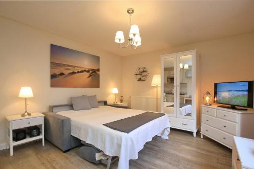 a bedroom with a large bed and a television at Strandvilla Krabbe Wohnung 02 in Boltenhagen