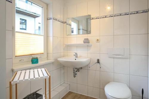 a white bathroom with a sink and a toilet at Strandvilla Krabbe Wohnung 02 in Boltenhagen