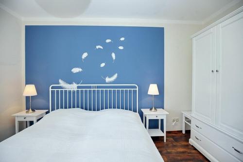 a bedroom with a bed with a blue wall at Dünenblick Wohnung 21 in Boltenhagen