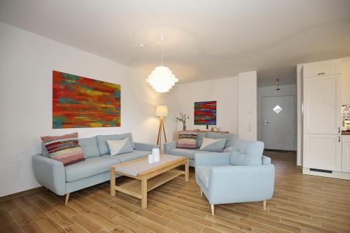 a living room with two couches and a table at Reethaus Am Mariannenweg 02a in Boltenhagen