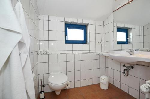 La salle de bains blanche est pourvue de toilettes et d'un lavabo. dans l'établissement Apartmenthaus Bull Wohnung 6, à Kühlungsborn