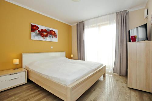 1 dormitorio con cama y ventana grande en Villa Sanddorn Wohnung 03, en Börgerende-Rethwisch