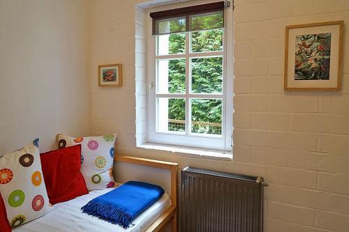 Pokój z oknem i łóżkiem z poduszkami w obiekcie Auf den Höfen Wohnung 02 w mieście Kühlungsborn