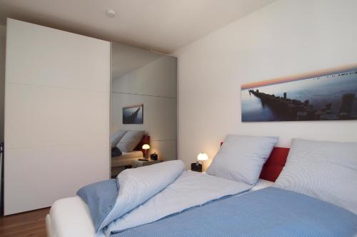 ハイリゲンダムにあるResidenz von Flotow Wohnung 09のベッドルーム1室(ベッド1台付)が備わります。壁には絵画が飾られています。