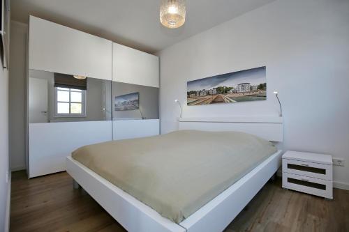 ハイリゲンダムにあるResidenz von Flotow Wohnung 10の白いベッドルーム(大型ベッド1台、窓付)