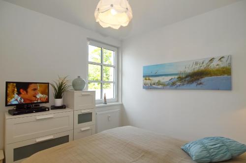 ハイリゲンダムにあるResidenz von Flotow Wohnung 16のベッドルーム(ベッド1台、テレビ、窓付)