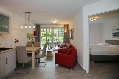 Linden-Palais Wohnung 06 في هيليغندام: مطبخ وغرفة معيشة مع طاولة وسرير