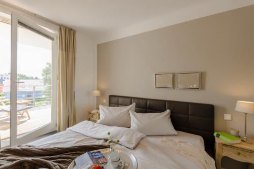 a bedroom with a bed with a table and a window at Villa Sanddorn Wohnung 11 in Börgerende-Rethwisch