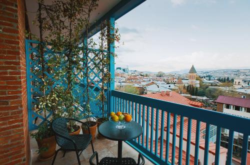 a balcony with a table with fruit on it at TbiliSee Hotel in Tbilisi City
