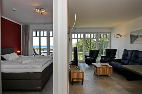 ein Schlafzimmer mit einem Bett und ein Wohnzimmer in der Unterkunft Linden-Palais Wohnung 18 in Heiligendamm