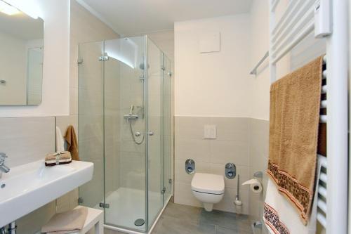 a bathroom with a shower and a toilet and a sink at Residenz von Flotow Wohnung 05 in Heiligendamm