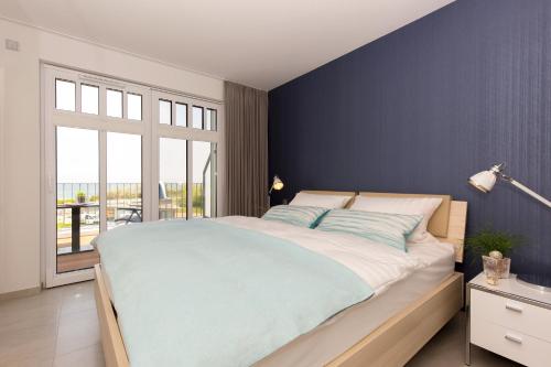 ハイリゲンダムにあるLinden-Palais Wohnung 35の青い壁のベッドルーム1室(大型ベッド1台付)