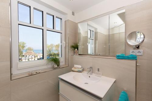 ハイリゲンダムにあるLinden-Palais Wohnung 35のバスルーム(洗面台、鏡、窓付)