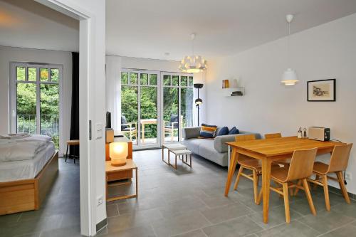 1 dormitorio y sala de estar con mesa y sofá en Linden-Palais Wohnung 21, en Heiligendamm