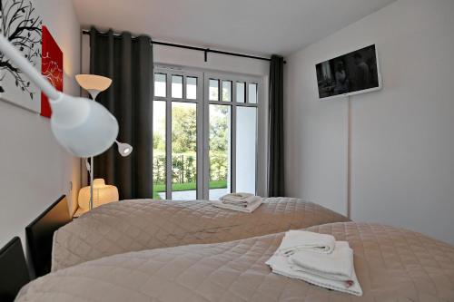 ハイリゲンダムにあるLinden-Palais Wohnung 04のベッドルーム1室(ベッド2台、窓付)