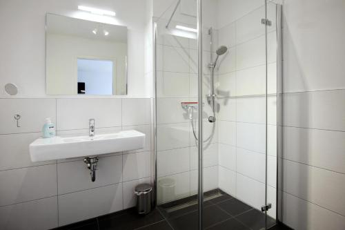 ハイリゲンダムにあるLinden-Palais Wohnung 04の白いバスルーム(シンク、シャワー付)