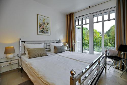 ハイリゲンダムにあるLinden-Palais Wohnung 39のベッドルーム(大型ベッド1台、大きな窓付)