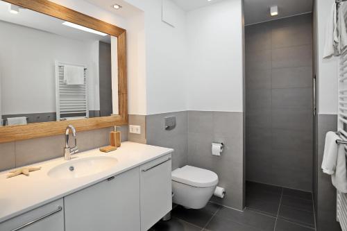 uma casa de banho com um lavatório, um WC e um espelho. em Linden-Palais Wohnung 34 em Heiligendamm